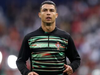 Joueur de football en tenue d'entraînement sur le terrain.