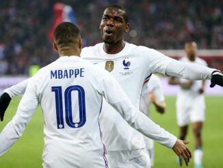 Deux footballeurs se félicitent sur le terrain.