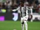 Joueur de football dribblant ballon en match.