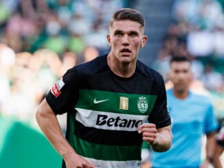 Joueur de football en maillot noir et vert sur terrain