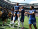 Joueurs de football célébrant un but sur le terrain.