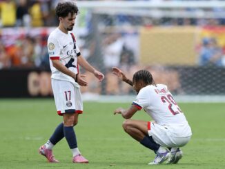 Deux footballeurs en discussion sur le terrain.