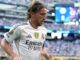 Joueur de football en maillot blanc sur le terrain.