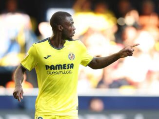 Joueur en maillot jaune sur le terrain de football.