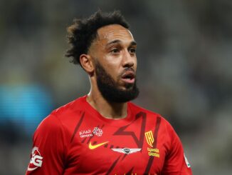 Joueur de football en maillot rouge sur le terrain.