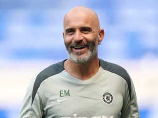 Homme souriant portant un maillot de Chelsea.
