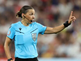 Arbitre de football désignant une direction.