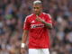 Joueur de football en maillot rouge sur le terrain.