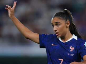 Footballeuse française en match, maillot bleu.