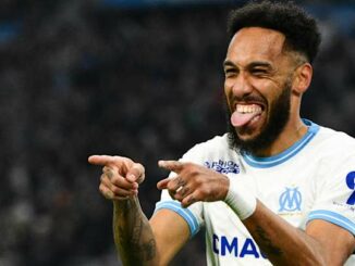 Joueur de football souriant sur le terrain.
