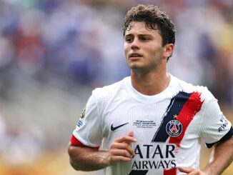Joueur de football en maillot PSG sur le terrain.