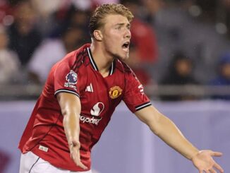 Joueur de football en maillot rouge sur le terrain.
