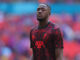 Joueur de football en maillot rouge sur le terrain.