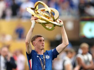 Joueur de football tenant un trophée doré.