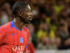 Joueur en maillot rouge lors d'un match de football.