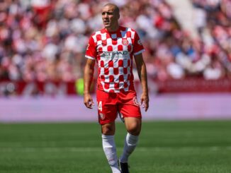 Joueur de football en maillot rouge et blanc.