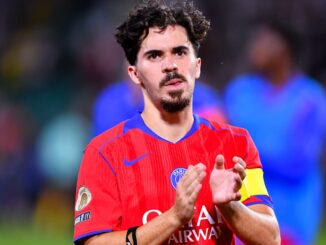 Joueur de football applaudissant sur le terrain.