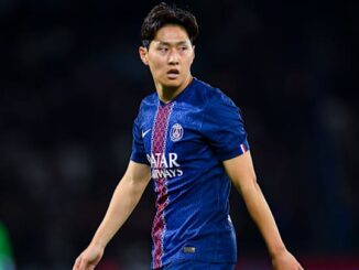Joueur de football en maillot bleu sur le terrain.