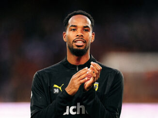 Joueur de football applaudissant sur le terrain.