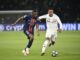 Deux footballeurs disputent un match.