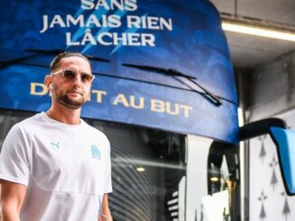 Homme devant un bus de football à Marseille.