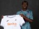 Joueur tenant un maillot de football blanc.