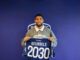 Homme tenant un maillot de football numéro 2030.