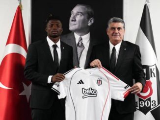 Deux hommes tiennent un maillot de football.