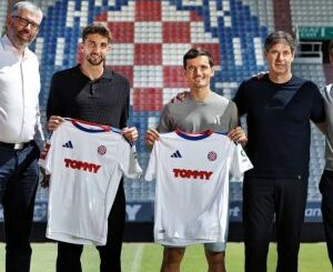 Cinq personnes tenant des maillots de football.