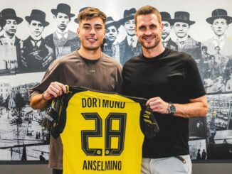 Deux hommes tenant un maillot de football Dortmund.