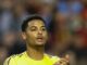 Homme en maillot jaune, mains jointes.
