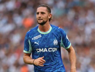 Joueur de football en maillot bleu sur le terrain.
