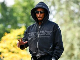 Personne en sweat à capuche et lunettes de soleil.