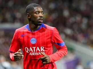 Footballeur en maillot rouge sur le terrain.