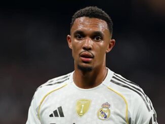 Joueur de football en maillot blanc sur le terrain.