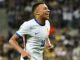 Joueur de football en maillot blanc souriant.