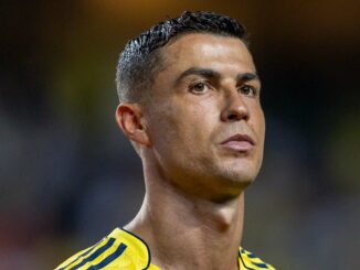 Homme en maillot de football jaune et bleu.