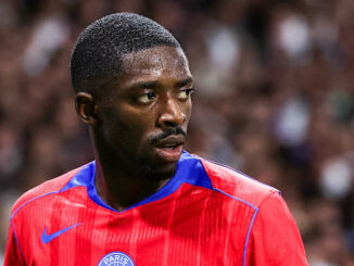 Joueur de football portant un maillot rouge sur le terrain.