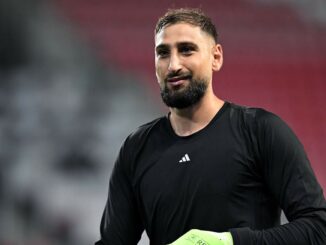 Homme en maillot noir sur terrain de sport.