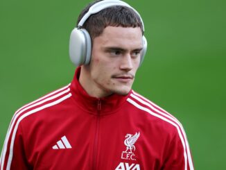 Footballeur en survêtement rouge avec casque audio