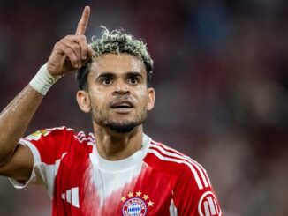 Joueur de football en maillot rouge pointant le doigt.