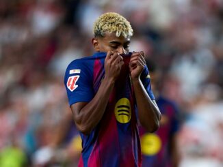 Joueur de football en maillot Barcelone cachant son visage.