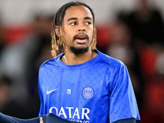 Joueur de football en maillot bleu sur le terrain.