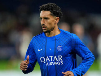 Joueur de football en tenue bleue sur le terrain.