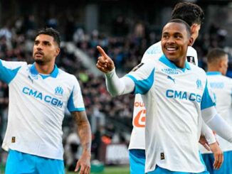 Joueurs de football en tenue blanche sur le terrain.