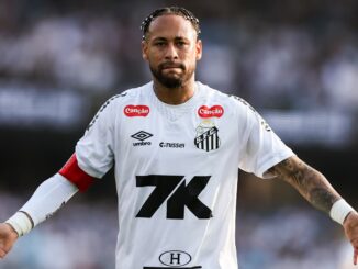 Footballeur en maillot blanc sur le terrain.