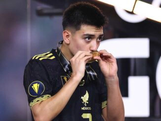 Joueur de football embrassant une médaille.