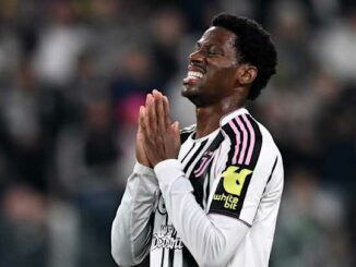 Joueur de football priant sur le terrain.