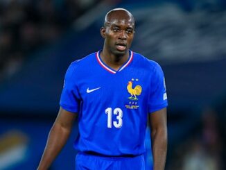 Joueur de football en maillot bleu sur le terrain.