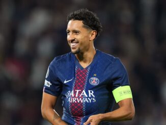 Joueur de football en tenue PSG sur le terrain.